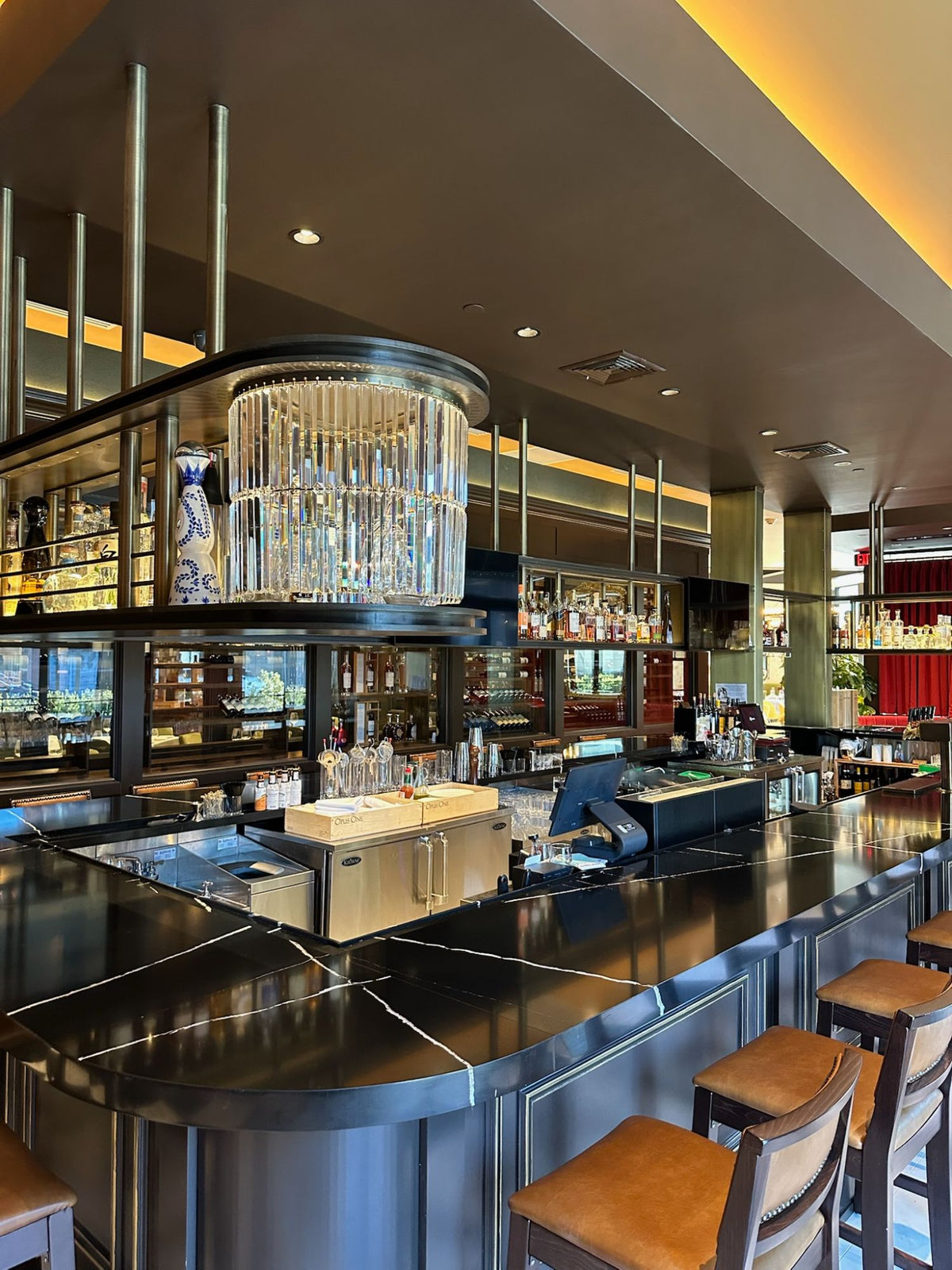 Railed shelves and round posts of the overhead bar rack at Masseria Italian Steakhouse, built by HM Metalworks