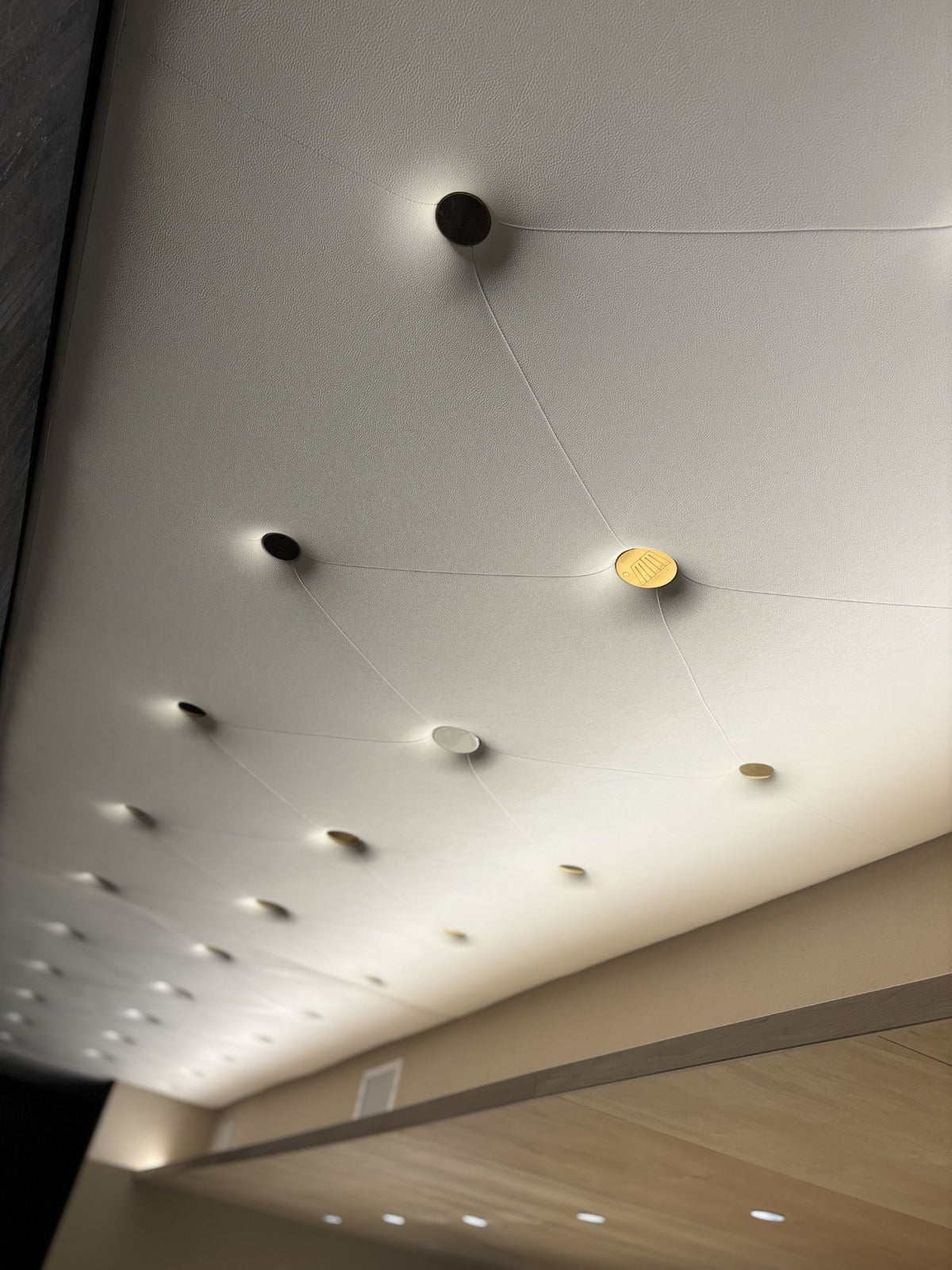 Large round metal buttons set into an upholstered panel at MM by Morimoto in Montclair, NJ, built by HM Metalworks